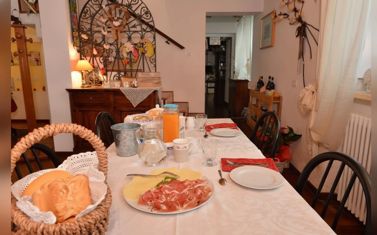 La tavola della colazione con pane, salumi, frutta e bevande