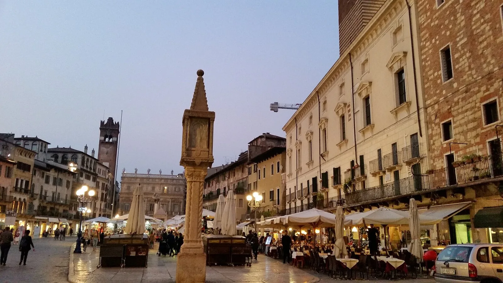 Piazza delle Erbe a Verona al tramonto, con il Capitello, la Torre del Gardello e i tavolini dei caffè