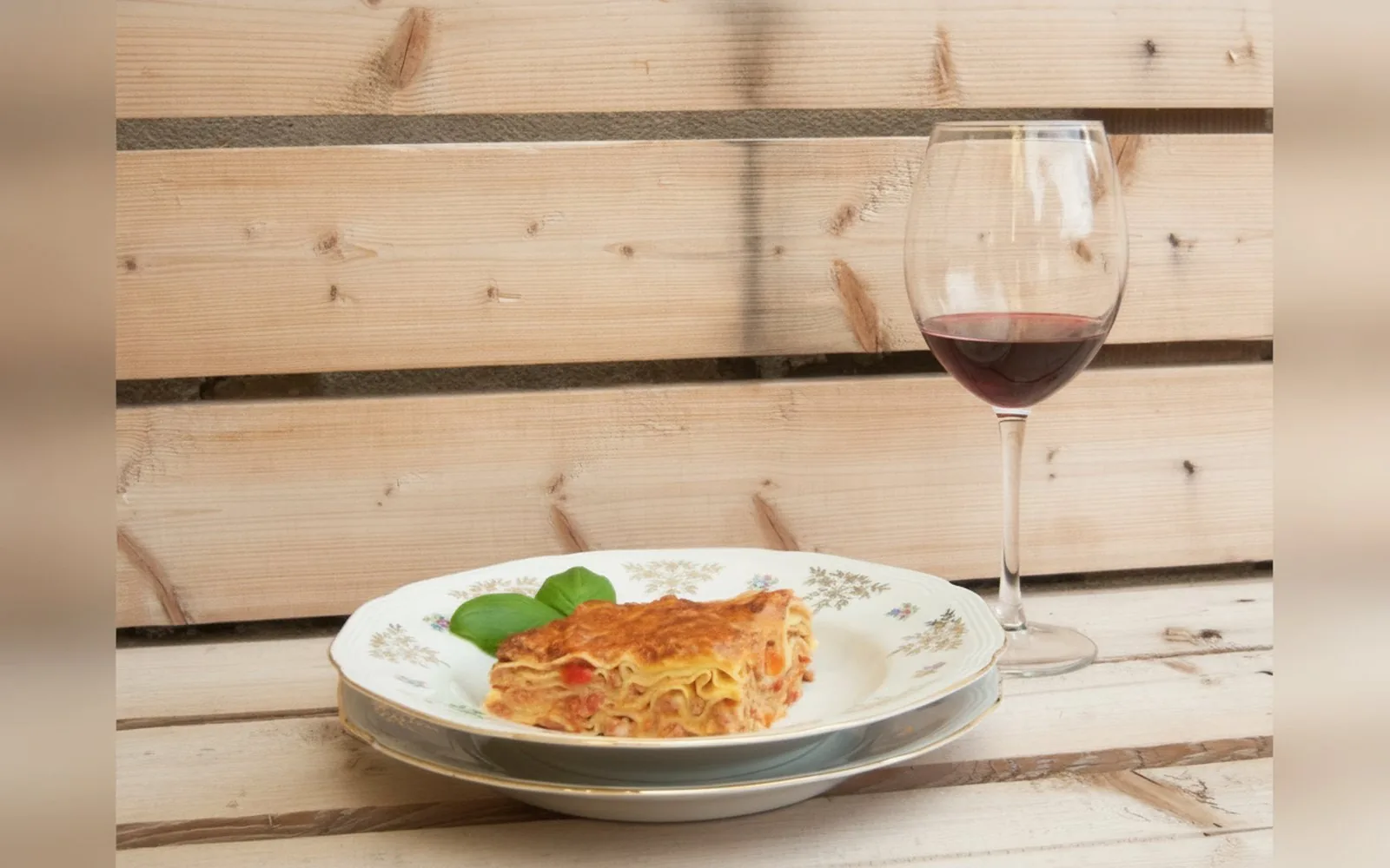 Un piatto di pasta fatta in casa servito con un calice di vino rosso